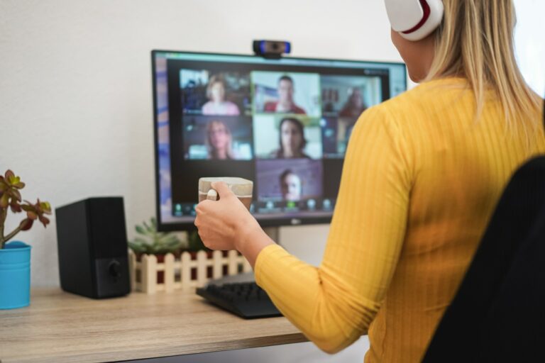 Young woman having a discussion meeting in video call with her team - Focus on hand